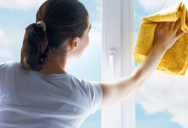 women is making her rooms window neat and claen