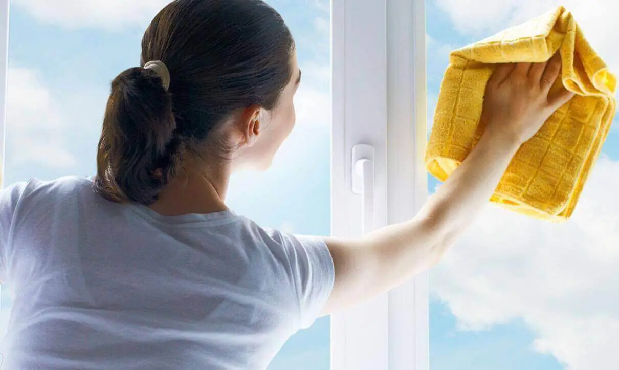 women is making her rooms window neat and claen